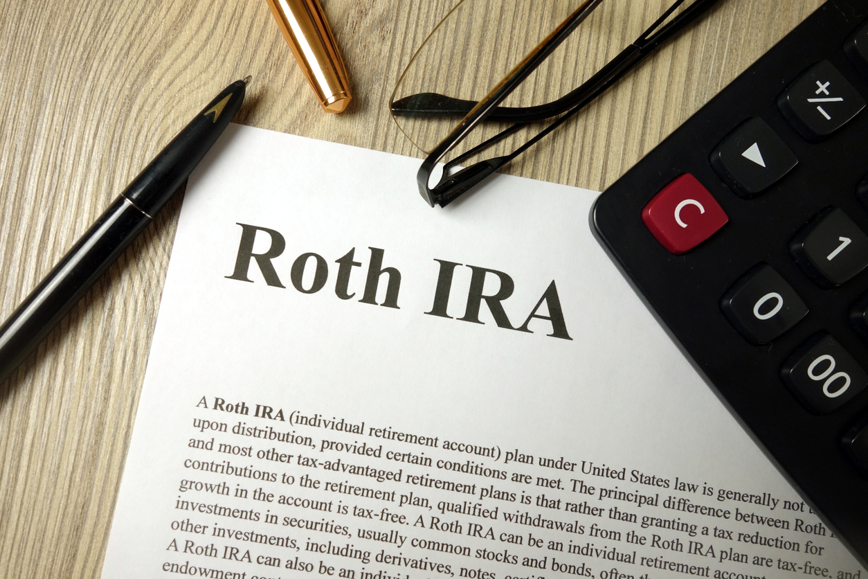 Roth IRA mockup with calculator pen and glasses